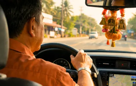 Chauffeur thaïlandais au volant d’une voiture privée accompagnant des clients en Thaïlande