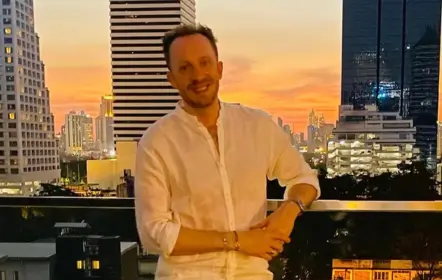Guillaume Cravate sur un rooftop de Bangkok au coucher du soleil, entre les gratte-ciel